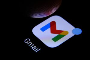 Google Gmail app and finger above it ready to press it seen on the screen of smartphone