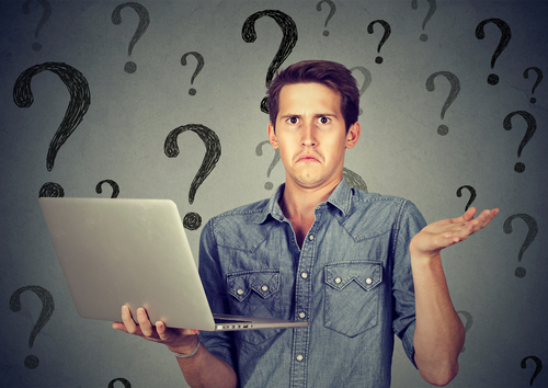 Perplexed young man with laptop many questions and no answer anonymous email concept