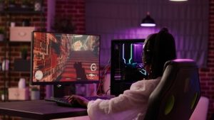 Over shoulder view of african american gamer girl playing online games using gaming pc setup spending relaxing time at home ikev2 concept