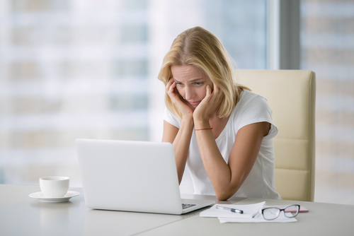 Portrait of young bored attractive woman at office desk